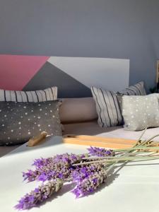 a bunch of purple flowers on a bed with pillows at Cabañas Los Mochuelos in Villa Cura Brochero +19 photos