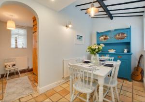 a dining room with a white table and chairs at Reading Room Cottage in Overstrand