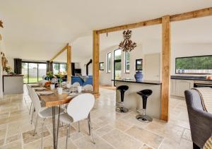 a kitchen and living room with a table and chairs at Roe Deer Barn in Briston