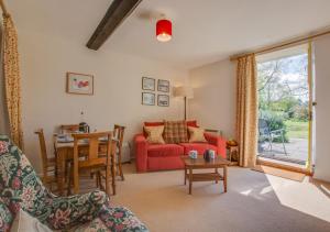 a living room with a red couch and a table at Reeve Cottage in Blakeney