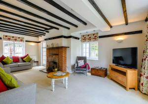 a living room with a fireplace and a television at Rose Cottage - West Runton in West Runton