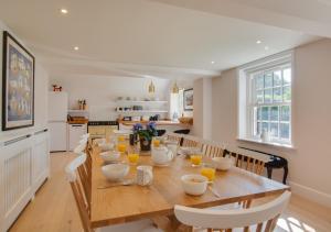 a kitchen and dining room with a wooden table and chairs at South Cottage in Antingham