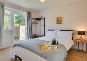 a bedroom with a bed with a tray of food on it at South Cottage in Antingham