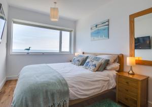 a bedroom with a large bed with a window at Seaspray in Sheringham