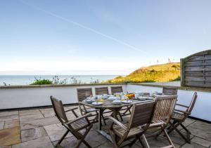 a table and chairs on a patio overlooking the ocean at Seaspray in Sheringham