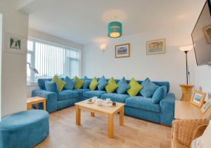 謝林漢姆的住宿－Seaspray，客厅配有蓝色的沙发和桌子