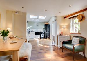 a kitchen and living room with a table and chairs at Robin Cottage in North Elmham