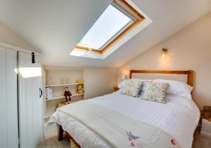 a bedroom with a large bed with a skylight at Robin Cottage in North Elmham