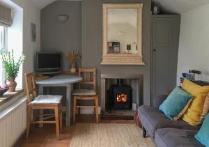 a living room with a couch and a fireplace at Poppy Cottage in Stiffkey