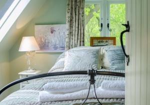 a bedroom with a bed with a window at Rose Lodge in Yaxham