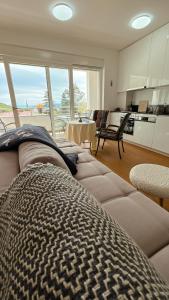 Una sala de estar con un sofá y una cocina. en seaview apartments croatia KARLA, en Mošćenička Draga