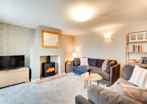 a living room with a couch and a fireplace at Sunset Cottage in Hickling