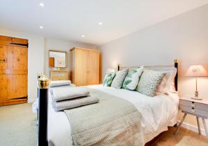 a bedroom with a large bed with pillows on it at Sunset Cottage in Hickling