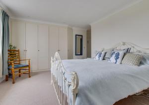 a bedroom with a large white bed with blue pillows at Sea Pie in Cley next the Sea