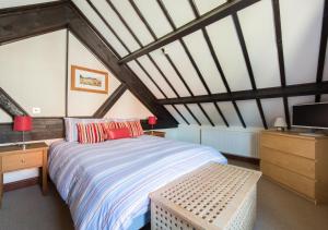 a bedroom with a bed and a desk and a tv at Swallow Barn in Bodham