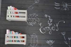 een zwarte muur met witte tekeningen erop met boekenplanken bij Ama(A’ in Fano