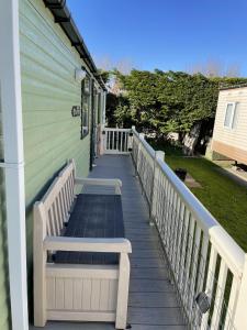 a porch with a bench on the side of a house at 6 berth pet friendly caravan on Sandy Glade (John Fowlers) Brean in Berrow