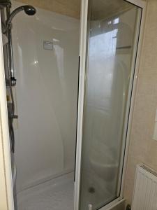 a shower with a glass door in a bathroom at 6 berth pet friendly caravan on Sandy Glade (John Fowlers) Brean in Berrow