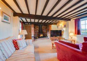 a living room with red couches and a fireplace at St Benets in Ludham