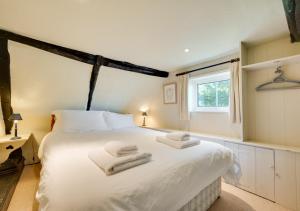 1 dormitorio con 1 cama blanca grande y toallas. en St Benets, en Ludham