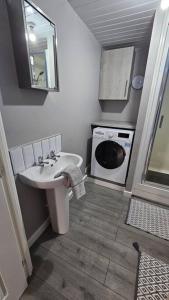a bathroom with a sink and a washing machine at Beautiful 'n' Cosy - City Center in Etruria