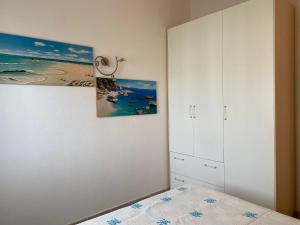 sypialnia z łóżkiem i obrazem na ścianie w obiekcie Casa Antonella w mieście Santa Teresa Gallura