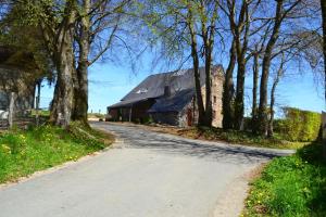 una strada che conduce a un vecchio fienile con alberi di Bidi's Lodge a Stavelot