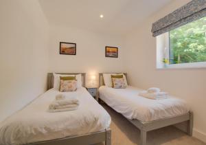 two twin beds in a room with a window at Station View in Cromer