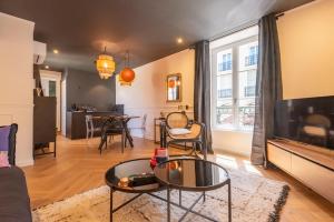 a living room with a couch and a table at Le Cosy Chic . Proche gare . Centre-ville Mâcon . Neuf . Climatisation . Design . Wifi . in Mâcon