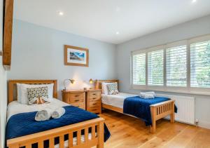 two beds in a room with two windows at South Way in West Runton