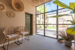 a lobby with two chairs and a large window at Le Cosy Chic . Proche gare . Centre-ville Mâcon . Neuf . Climatisation . Design . Wifi . in Mâcon