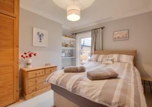 a bedroom with a large bed and a window at Staithe Cottage in Heacham