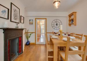 a dining room with a table and a fireplace at Staithe Cottage in Heacham