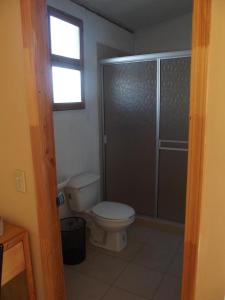 a bathroom with a toilet and a glass shower at Casa Campo Rancho Villarino in Ensenada