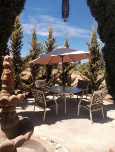 a table and chairs with an umbrella and a fountain at Casa Campo Rancho Villarino in Ensenada