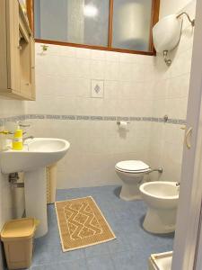 La salle de bains est pourvue d'un lavabo et de toilettes. dans l'établissement La Veranda Beach Paestum, à Paestum