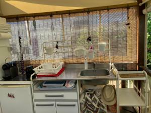 una cucina con lavandino e gabbia per uccelli di MOBIL HOME 3 chambres, 6 couchages, RAMATUELLE ST TROPEZ, PLAGE DE PAMPELONNE a Saint-Tropez