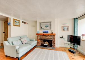 een woonkamer met een bank en een open haard bij Tern Cottage in Wells next the Sea