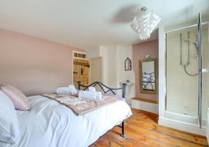 een slaapkamer met een wit bed en een douche bij Tern Cottage in Wells next the Sea