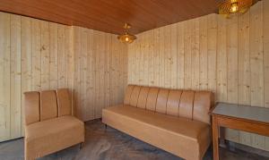two chairs and a table in a room with wooden walls at Treebo Trend Raj Mall Road in Mussoorie