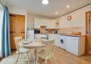 a kitchen with a table and chairs in a room at Sunset Lodge in Wighton