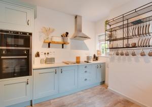 a kitchen with blue cabinets and white walls at The Bailey in Holt