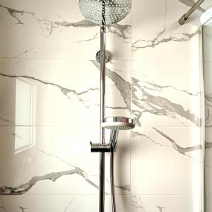 una ducha en un baño con paredes de mármol en seaview apartments croatia KARLA, en Mošćenička Draga