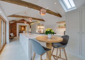 a kitchen with a wooden table and blue chairs at The Granary in Banningham