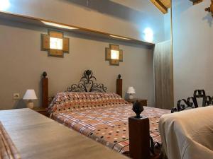 a bedroom with a bed and two chairs and lights at Wooden interior in village krini. in Corfu Town