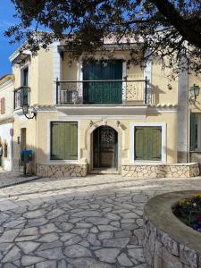 a large building with a balcony on top of it at Wooden interior in village krini. in Corfu Town