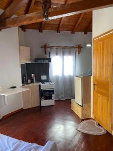 a room with a kitchen with a refrigerator and a stove at Wooden interior in village krini. in Corfu Town
