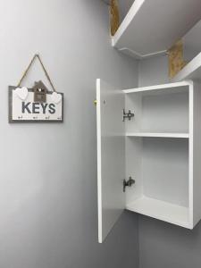 a white door with a key sign on a wall at Wooden interior in village krini. in Corfu Town