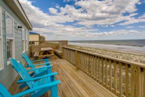 a deck with two chairs and a table and the beach at Beachfront Emerald Isle Vacation Rental with Deck! in Emerald Isle