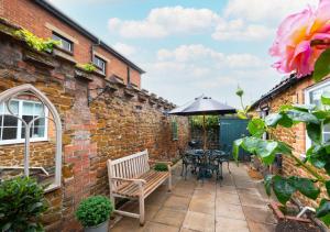 a patio with a table and an umbrella at The Dutch House in Snettisham